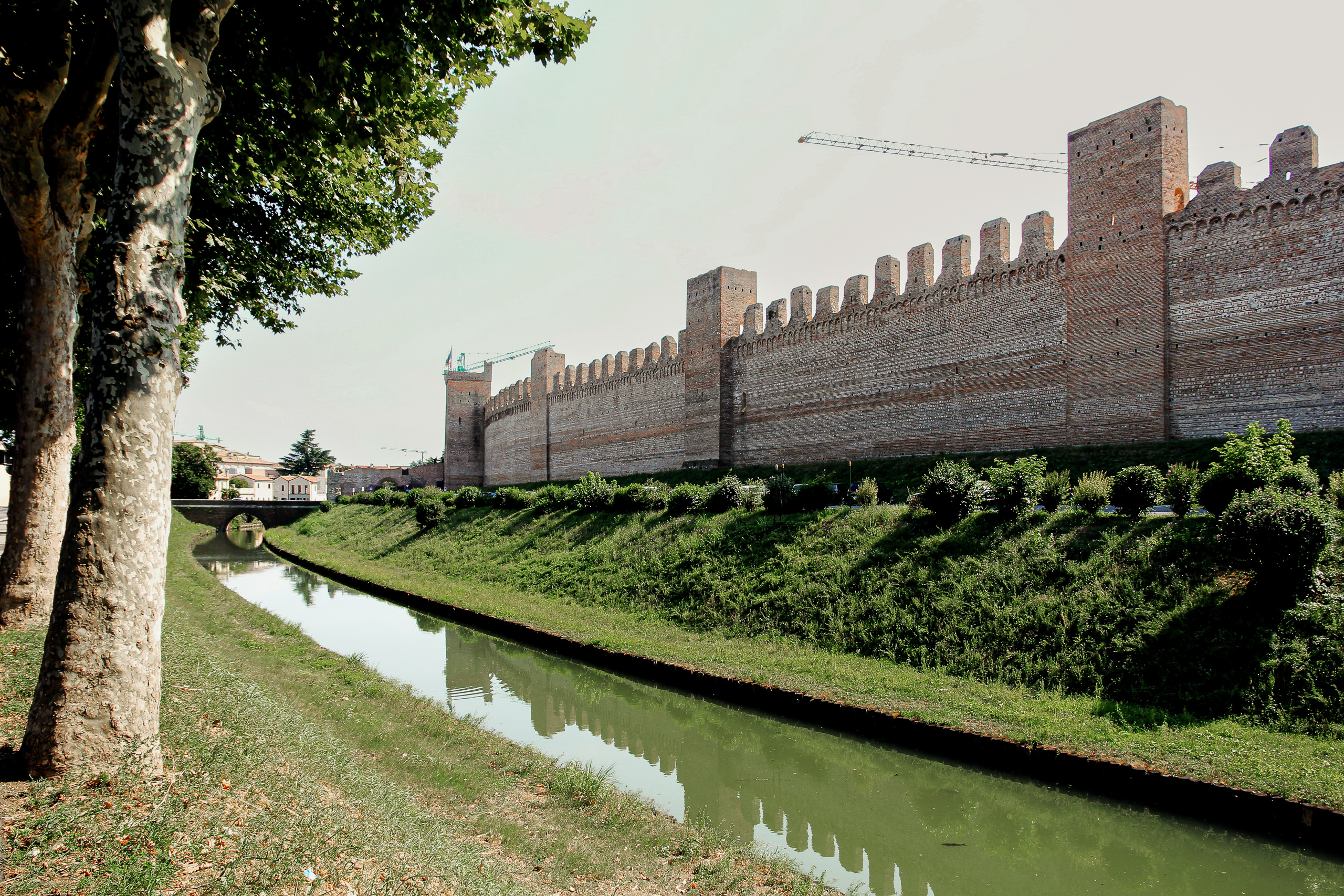 Cittadella: Zinnenmauer und Wassergraben, dahinter ragt ein Kran
